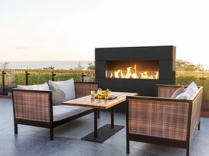 American Fyre Designs Milan Tall fireplace on an outdoor terrace overlooking the ocean